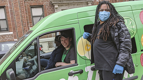 People posing next with van